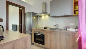 Una cocina moderna con armarios de madera, una campana extractora de acero inoxidable y un horno empotrado.