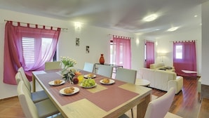 Un comedor con una mesa dispuesta para cuatro, un sofá y una mesita auxiliar.