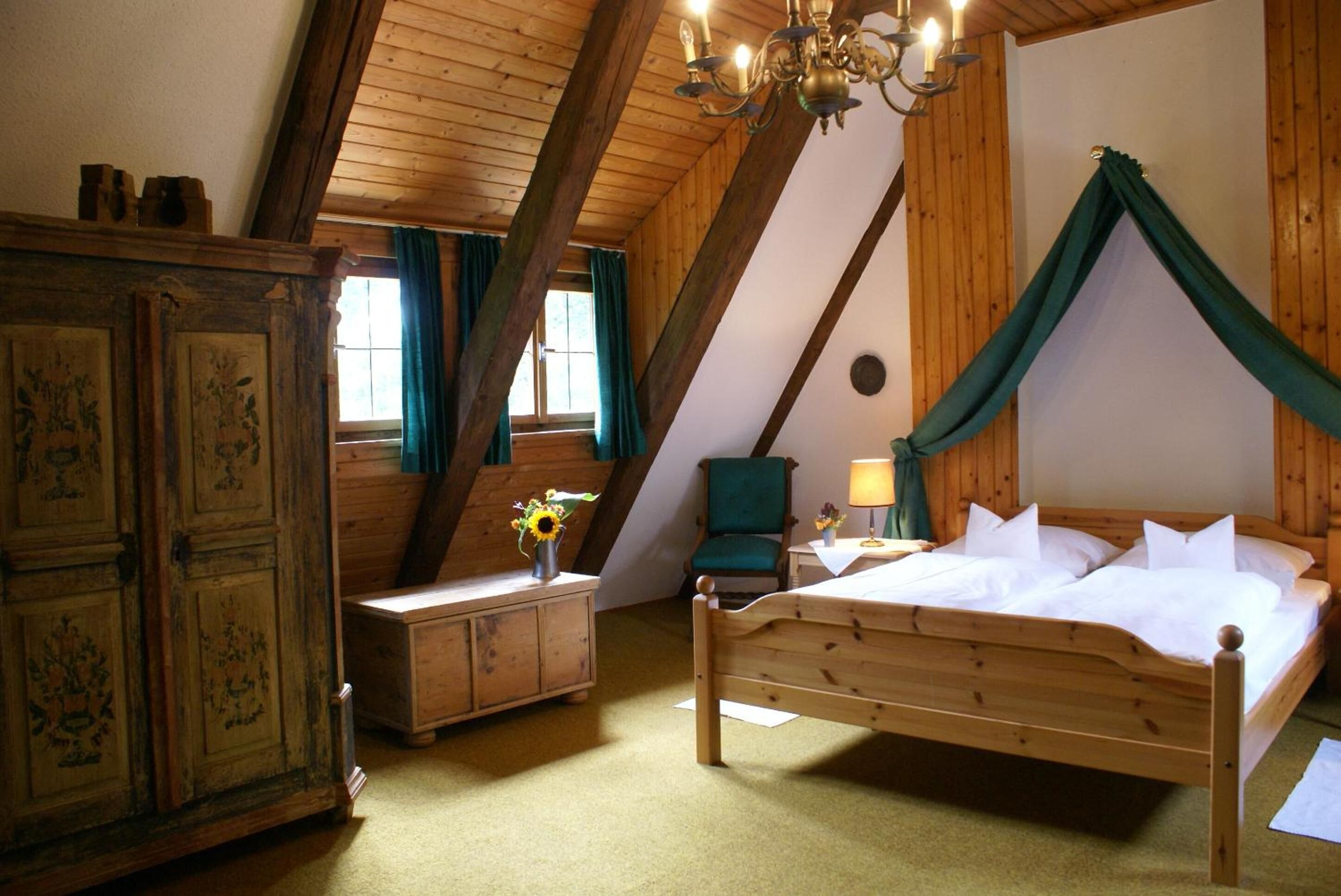 Une pièce comprenant un lit en bois, une table de chevet, une lampe, une chaise et un placard.