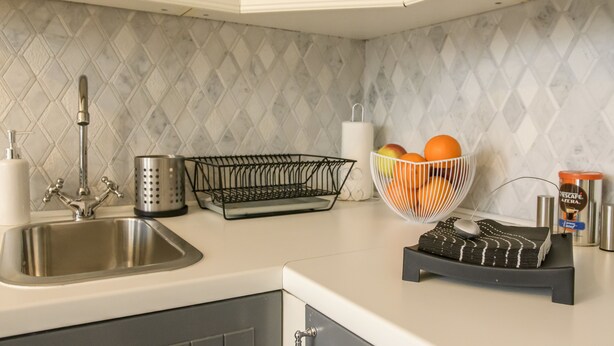 A kitchen with a sink, a fruit basket, a coffee maker, and a kettle. - Rondo ONZ Jana Pawła II 26 (Warsaw)