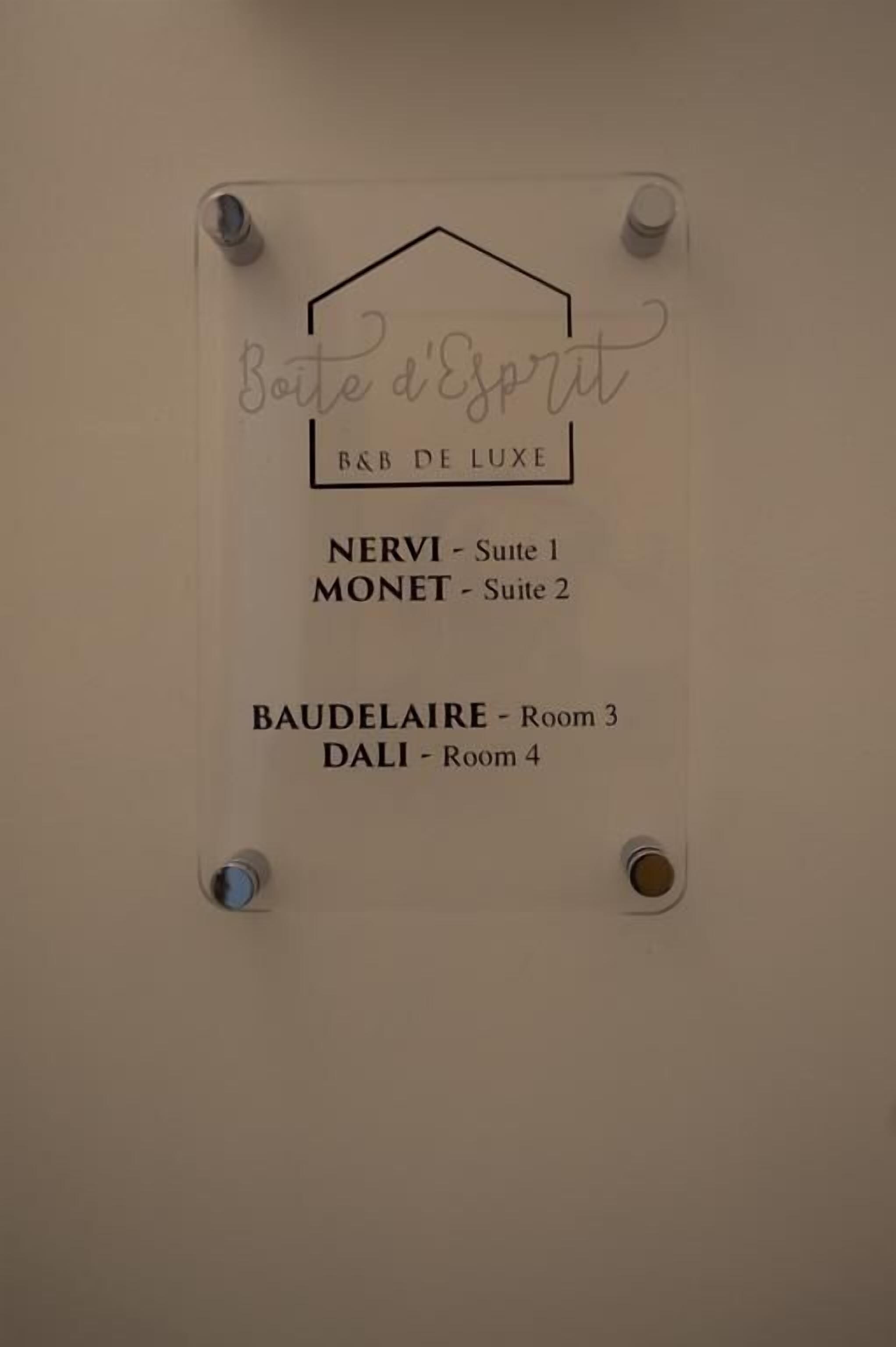 A hotel room sign with room names and suite numbers.