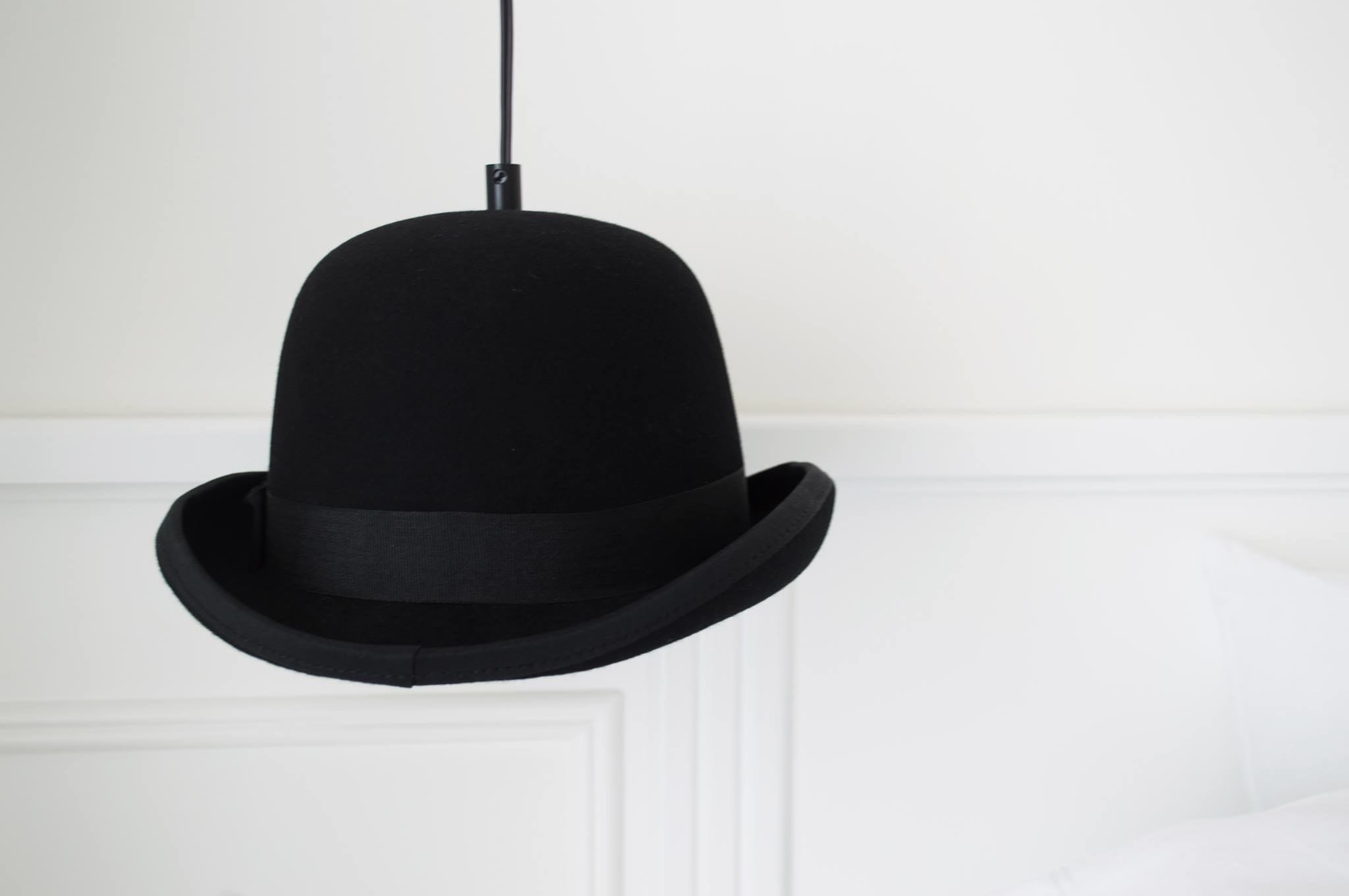 A black hat hanging from a ceiling.