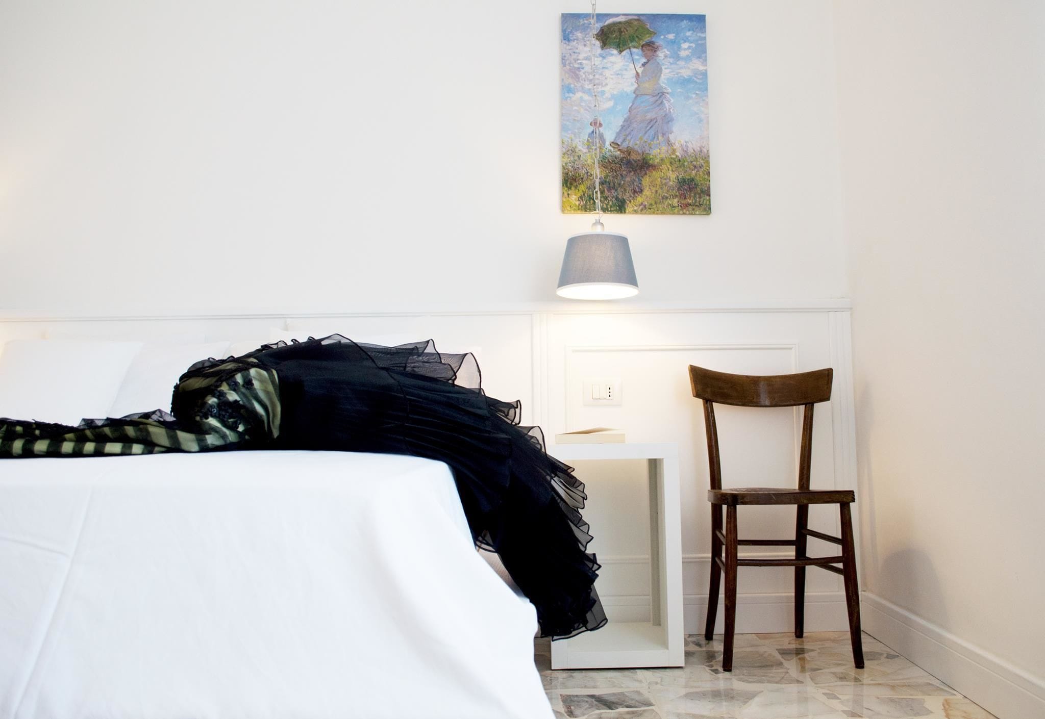 Une chambre à coucher avec un lit, une chaise, un bureau et un tableau au mur.