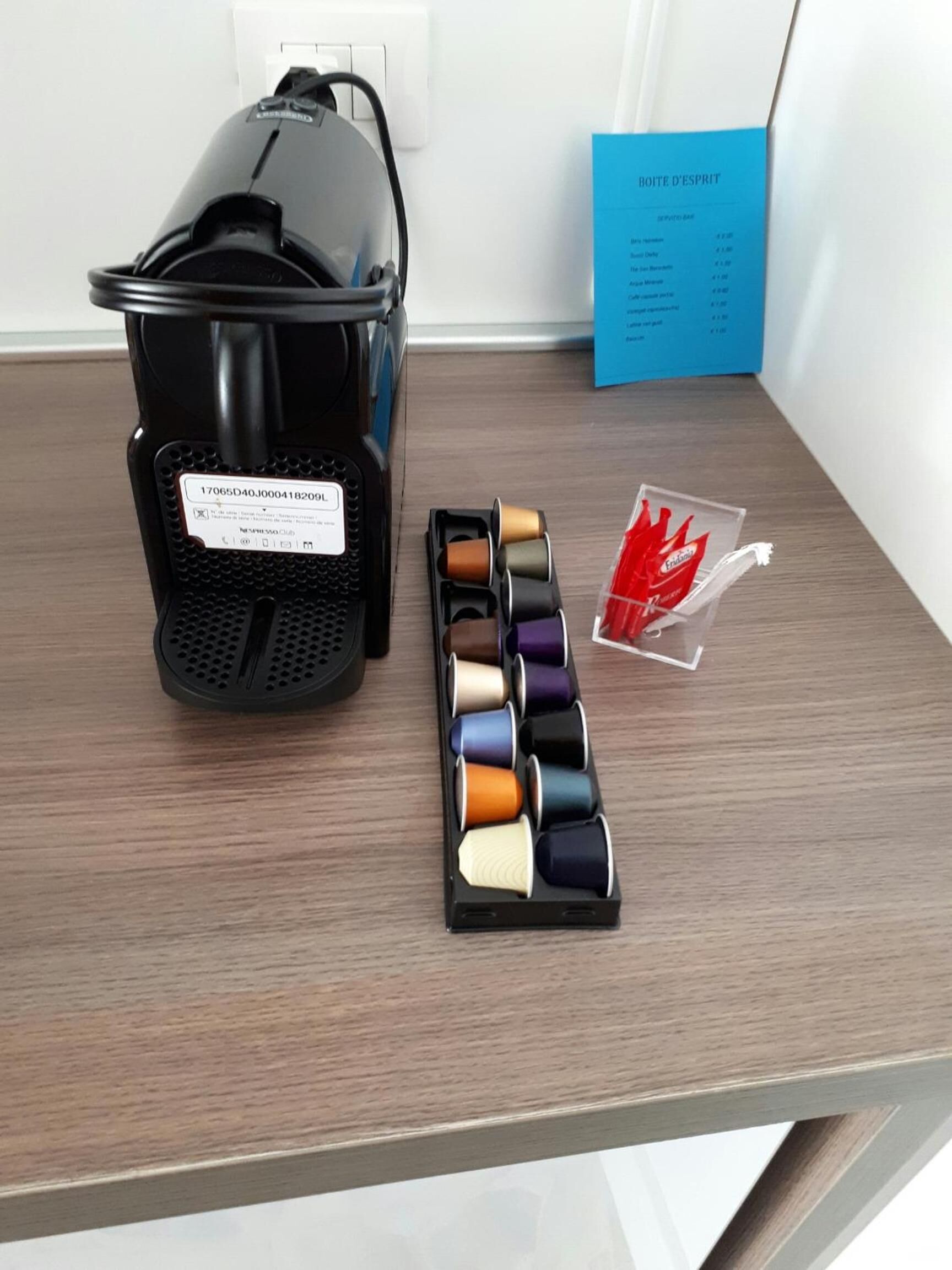 A black suitcase with a visible serial number, a set of spools with various thread colors, and a blue card with text.
