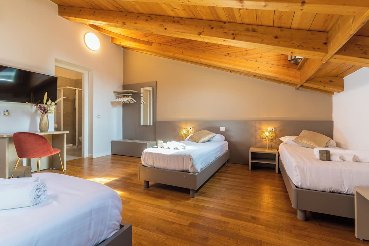 A modern bedroom with a wooden ceiling, a bed, a desk, and a chair.
