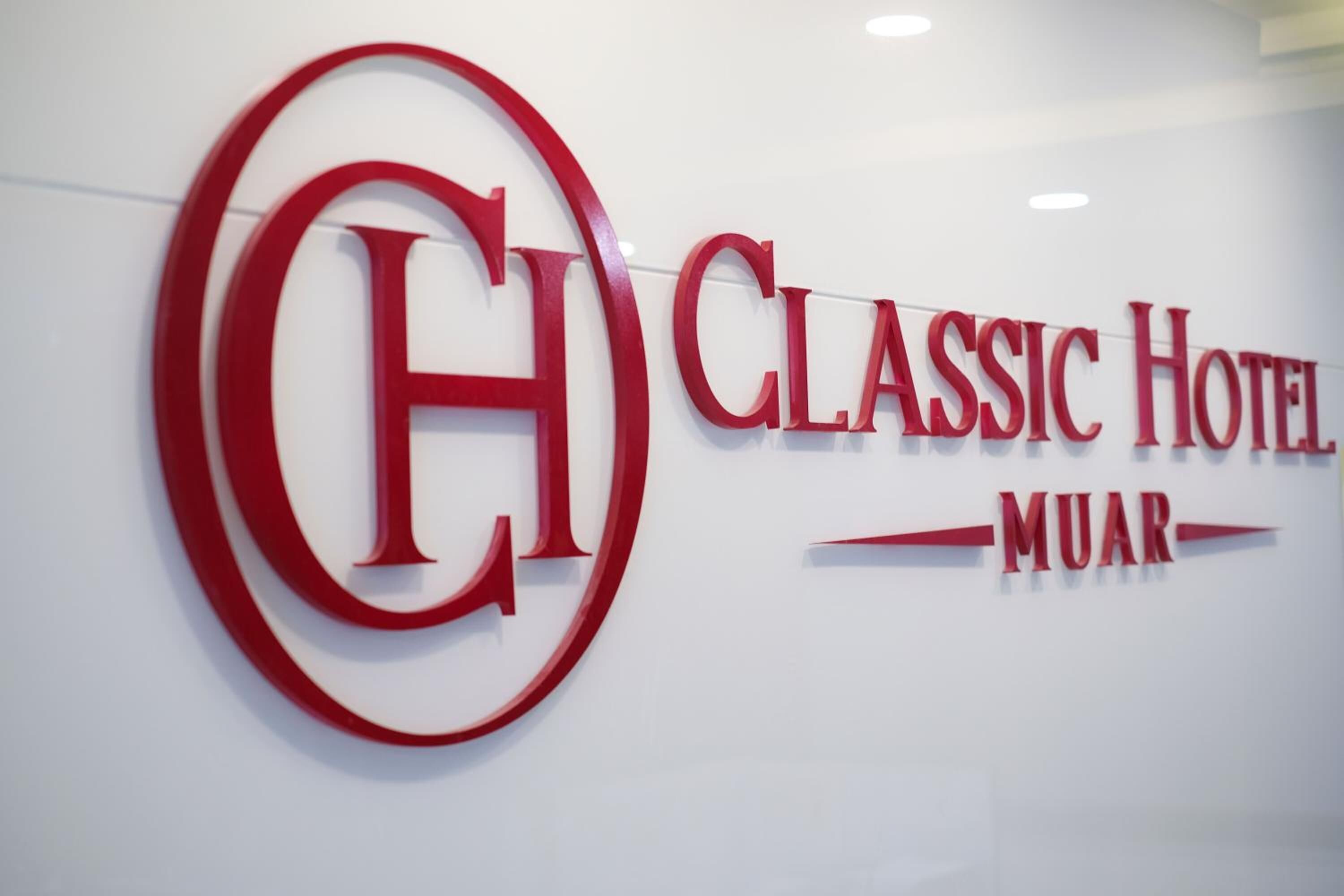 A hotel sign with a large red 'CH' logo and the name 'CLASSIC HOTEL MUAR'.