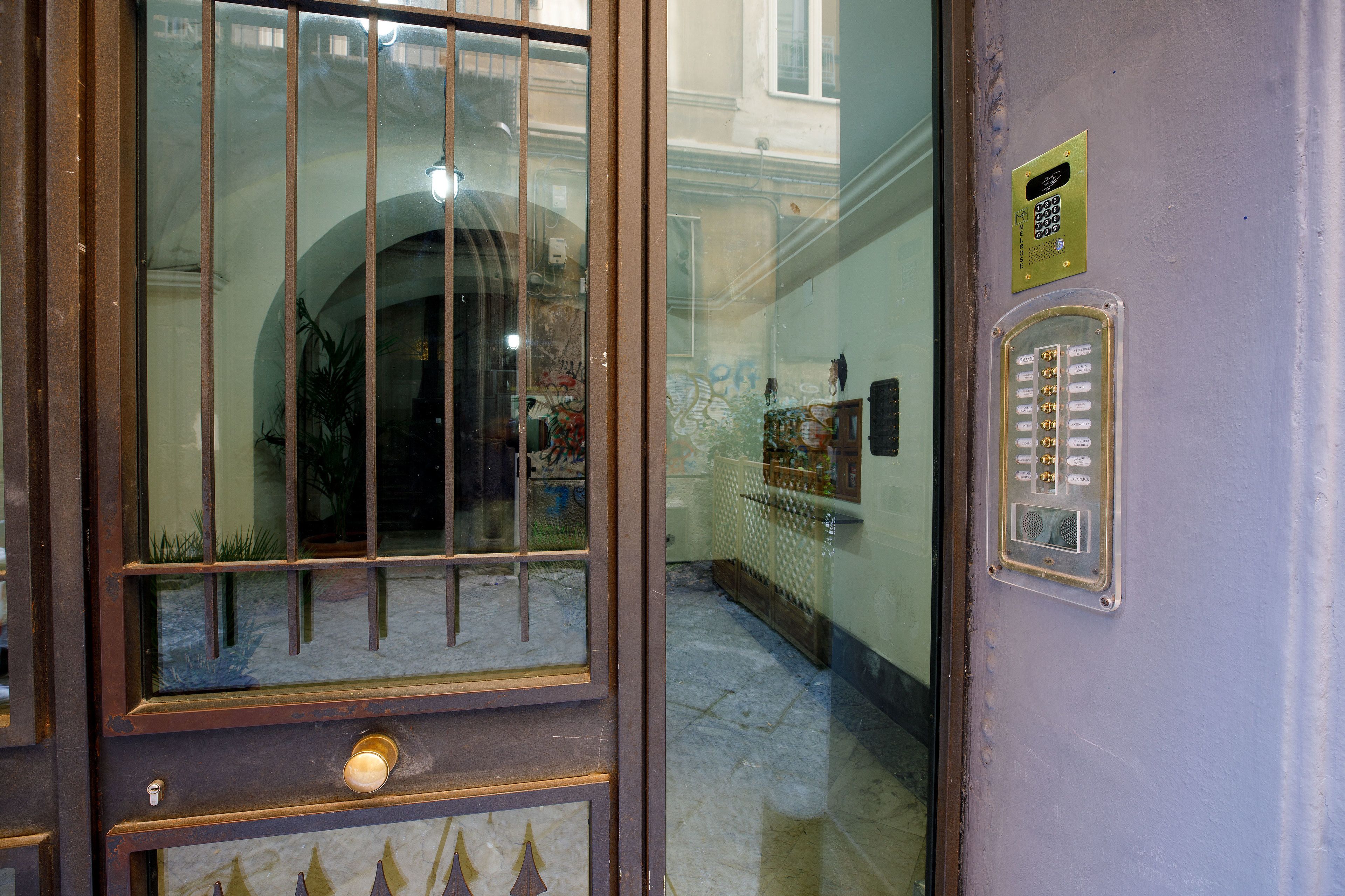 A door with a glass panel, a keypad, and a small sign on the wall.