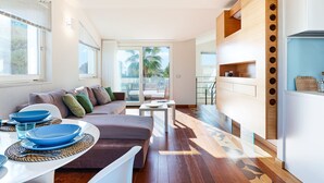 Una sala de estar moderna con un sofá, una mesa de centro y un comedor con platos azules.