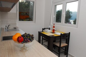 Apartamento básico, terraço, vista para o mar | Opções para refeição no quarto