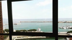 A marina with boats docked, a lighthouse, and a clear view of the sea. - Guest House Domus Cicerone (Formia)