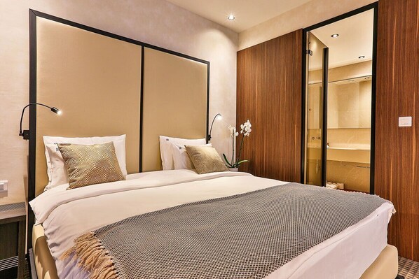 A hotel room with a large bed, a wooden wardrobe, and a mirror. - Hotel Kalos (Boreti)