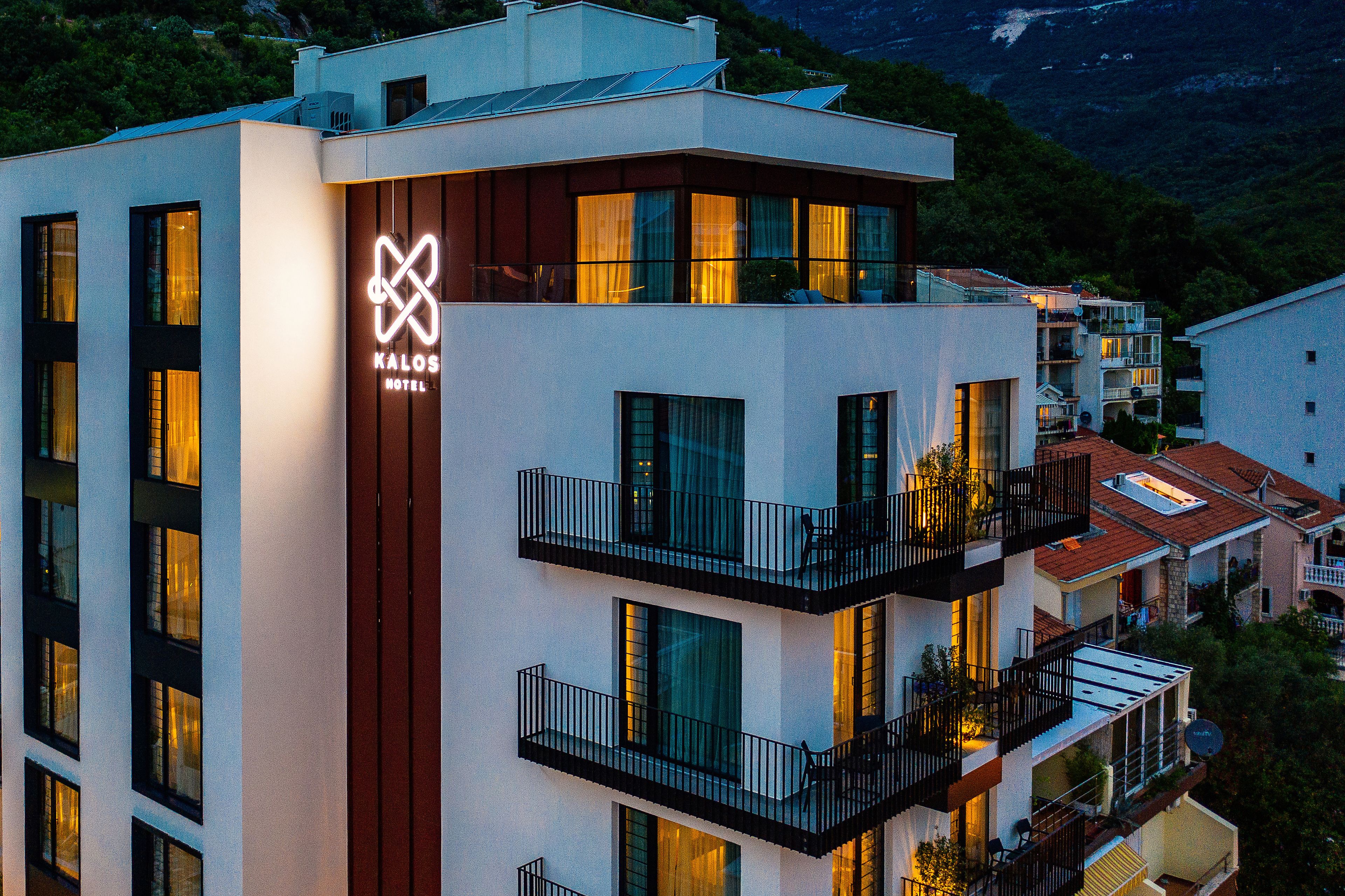 A modern hotel building with multiple balconies and large windows.