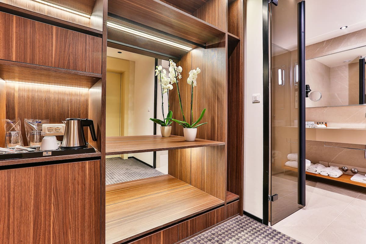 A modern bathroom with wooden cabinetry, a glass shower enclosure, and a mirror.