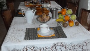 A dining table set with breakfast items, including croissants, fruit, and beverages. - Chambres d'Hotes Bel Air (La Selle-Craonnaise)