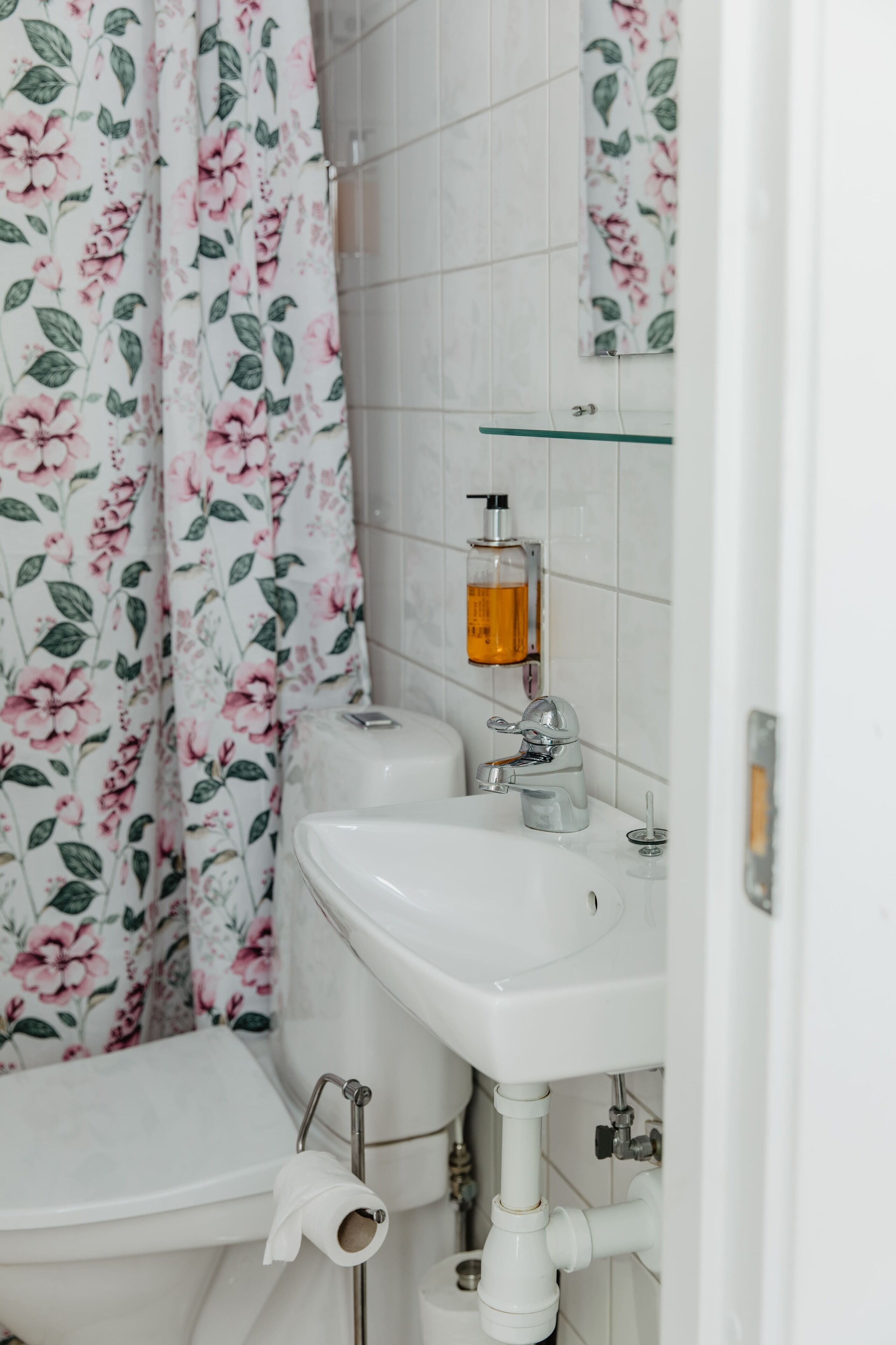 A bathroom with a toilet, sink, and shower curtain.