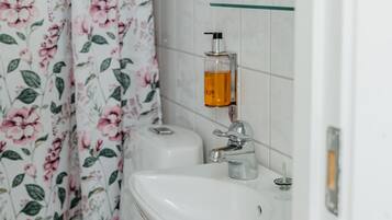 A bathroom with a toilet, sink, and shower curtain.
