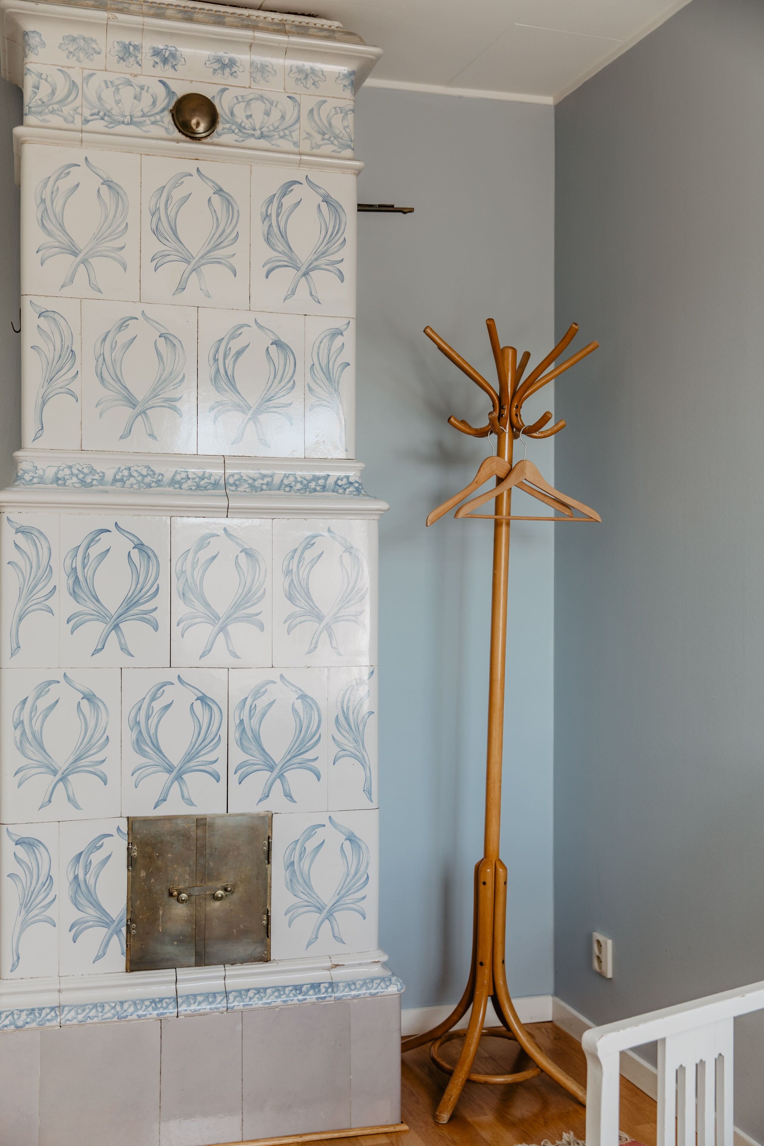 Una habitación con chimenea de baldosas, perchero y cuna blanca.