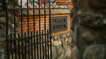 Una reja metálica con un muro de ladrillo y un letrero que dice "SLOTTS VILLAN".
