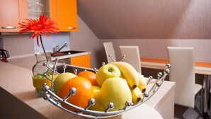 A fruit bowl on a table with a vase of flowers. - Ferienwohnungen Cella (Zell (Mosel))