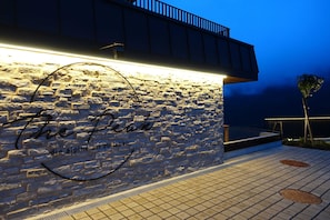 A stone wall with a sign that reads 'The Peak' and 'die alpine art zu leben'.