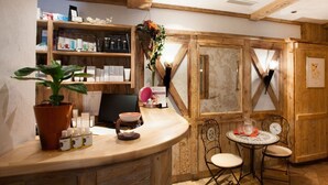 Un interior de madera con un mostrador, sillas y estantes con diversos objetos.