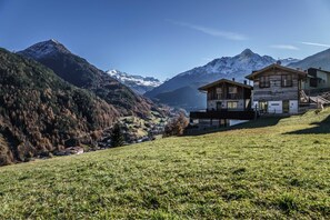 A mountain landscape with two wooden buildings, one with a balcony, and a clear sky. - Hunting Chalet - The Peak Sölden (Sölden)
