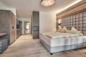 Ein modernes Schlafzimmer mit einem großen Bett, einem Holz-Kopfteil, einer eingebauten Bank und einem Flur, der in einen anderen Raum führt.