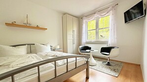 Um quarto moderno com cama, mesa de cabeceira e janela com cortinas.