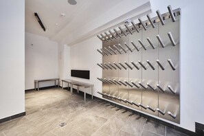 A modern bathroom with a large mirror, a bench, and a wall-mounted towel rack. - Bergsteiger Chalet - The Peak Sölden (Sölden)