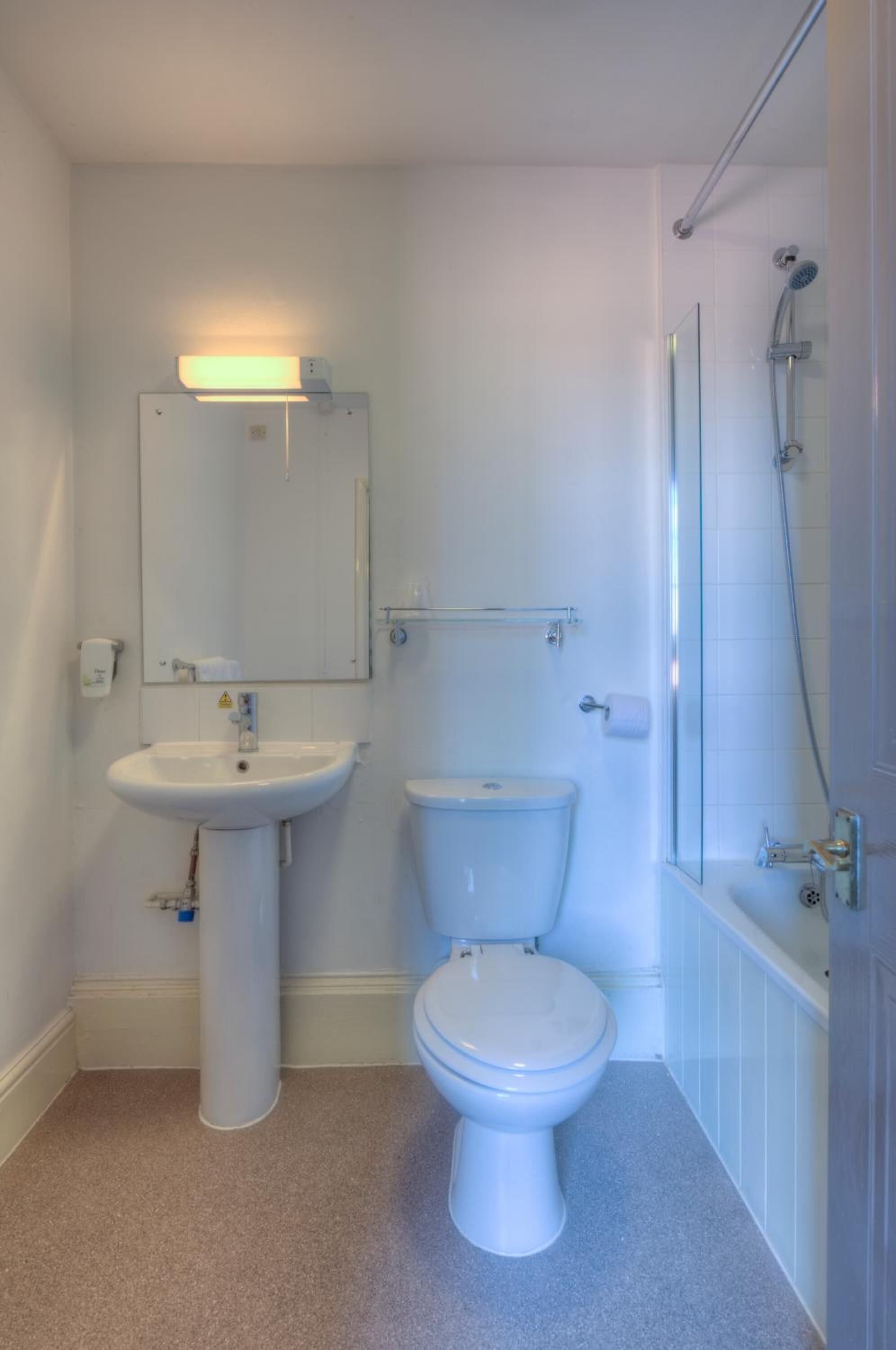 A bathroom with a white sink, toilet, and shower.
