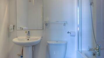 A bathroom with a white sink, toilet, and shower.