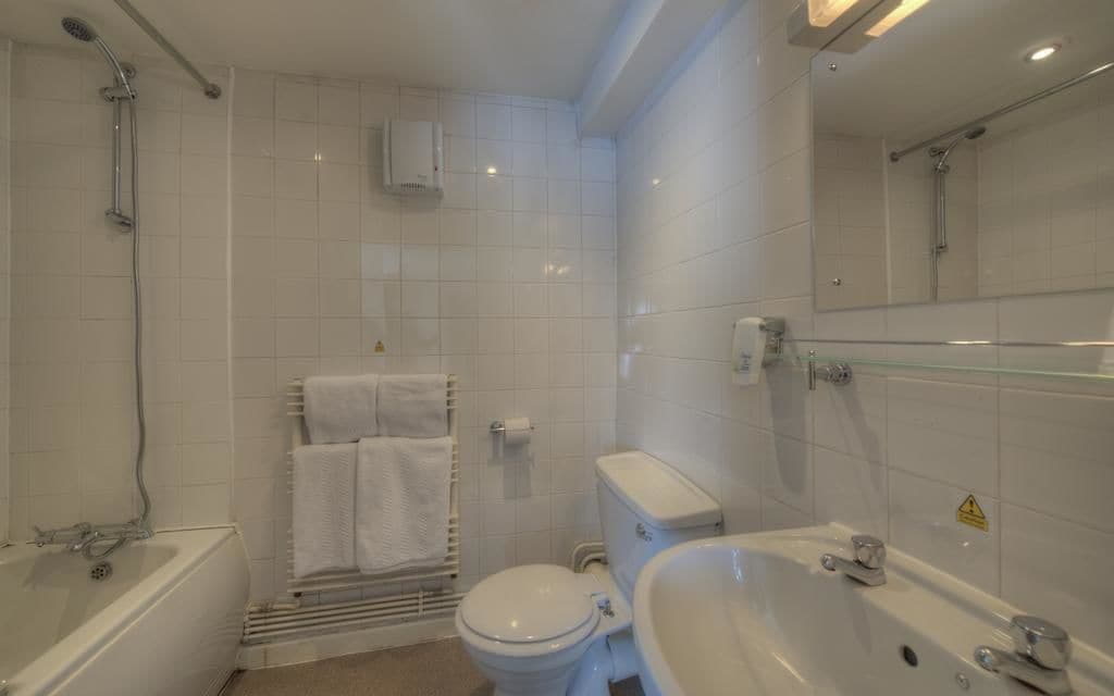 Ett modernt badrum med badkar, toalett och handfat.