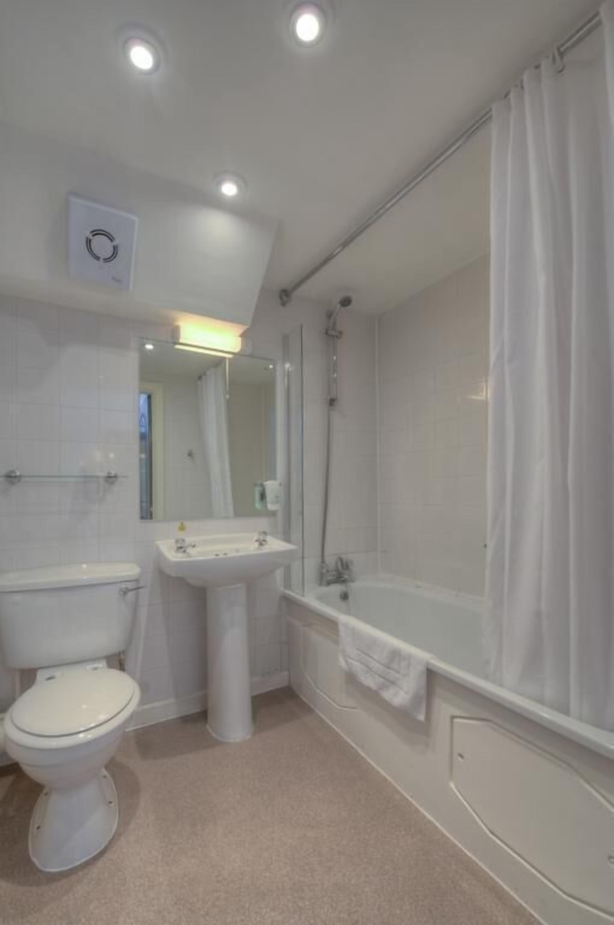 Une salle de bain avec des toilettes, un lavabo et une baignoire.