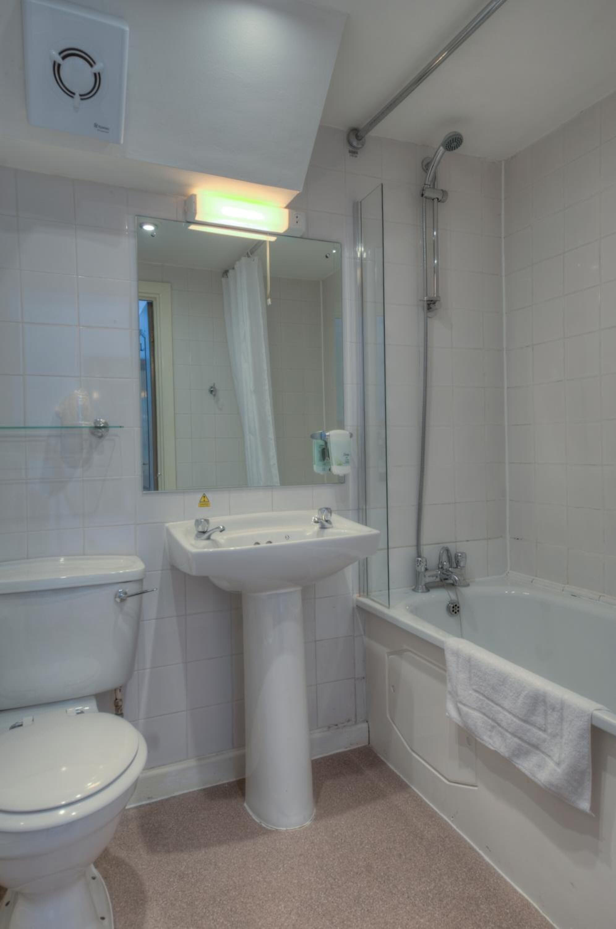 A bathroom with a toilet, sink, and bathtub.