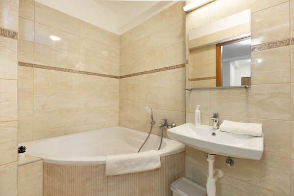 Un baño con una bañera, un lavabo y un espejo.