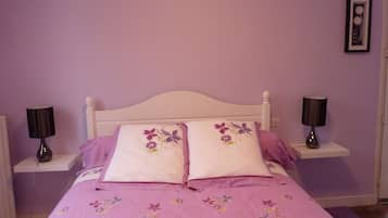 Ein Schlafzimmer mit einem Bett, zwei Nachttischen und einem Wandbild.