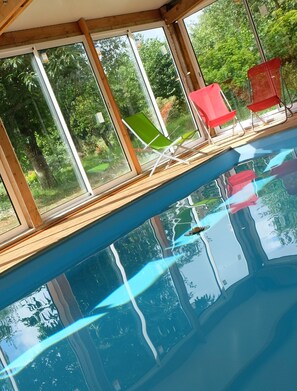 Een binnenzwembad en ligstoelen