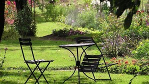 A garden with a table and two chairs. - Chambres d'Hôtes La Semondière (Saint-Thomas-de-Courceriers)