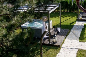A hot tub with a canopy, surrounded by a stone pathway and a wooden deck. - Guest house Oreskovic (Plitvicka Jezera)