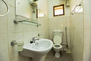 A bathroom with a white sink, a toilet, and a glass shower enclosure. - Corinya Serviced Apartments (Entebbe)
