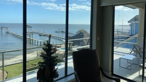 A room with large windows overlooking a pier and the sea. - The Bay House Kemah - Houston area Bayfront Home w/ Elevator & Bay Views (Kemah)