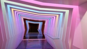 Un pasillo con una serie de paredes concéntricas y cambiantes de color.