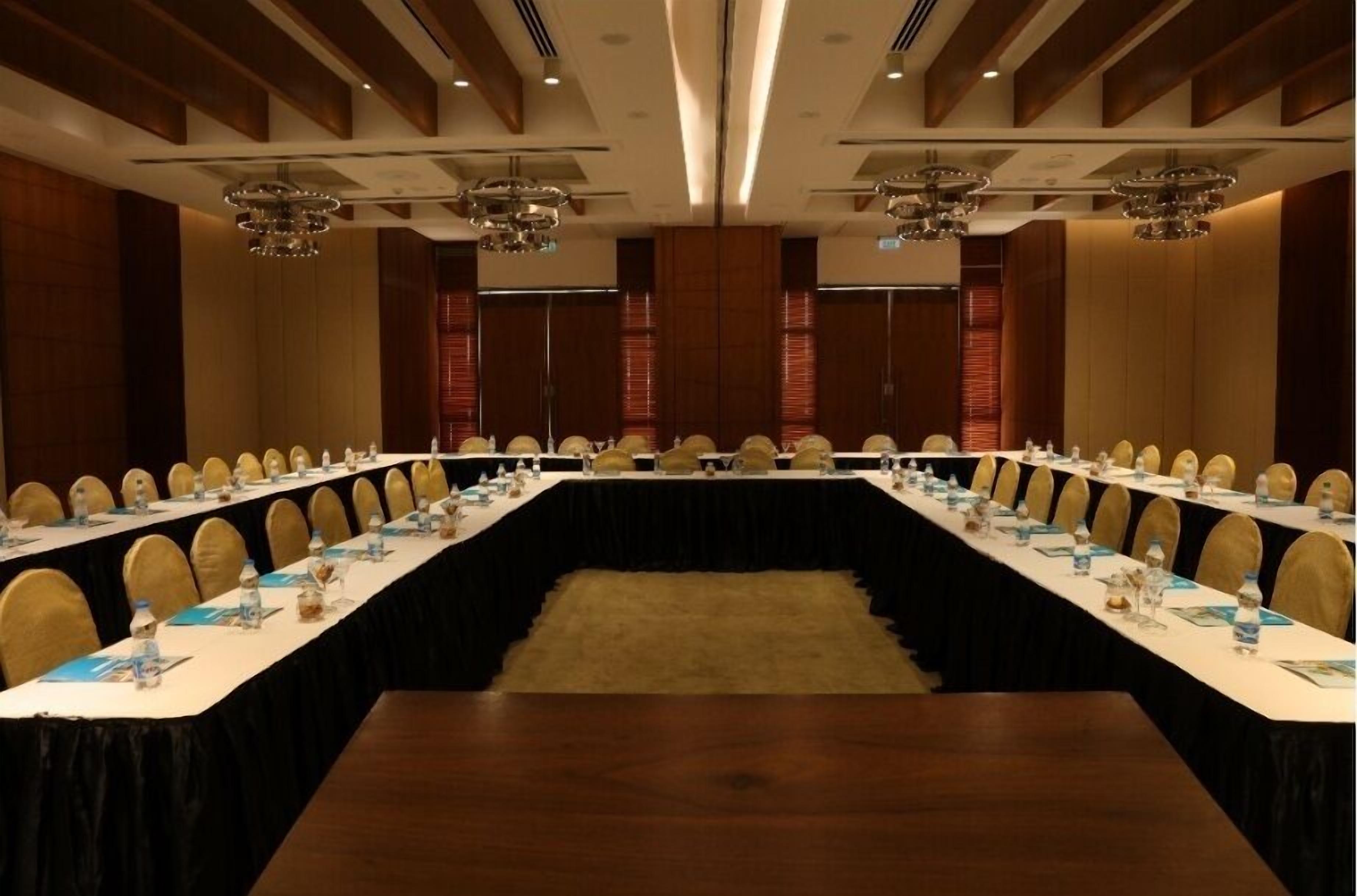 A conference room with a long table, chairs, and a carpeted floor.