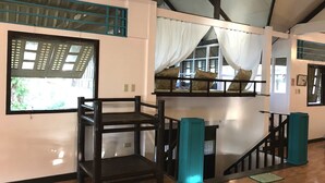 A room with a wooden floor, a bunk bed with a white canopy, and a window with a view of greenery. - C Donata Bed & Breakfast Guesthouse (Tagaytay)