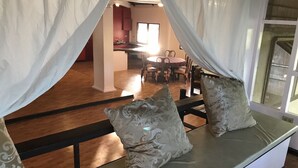 A room with a bed, a window with curtains, and a view of a dining area. - C Donata Bed & Breakfast Guesthouse (Tagaytay)