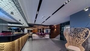 A modern reception area with a reception desk, seating area, and a decorative chair. - Donautica Hotel & Restaurant (Fadd)