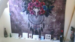 Una escalera con una obra de arte en la pared que presenta un diseño floral y con atrapasueños.
