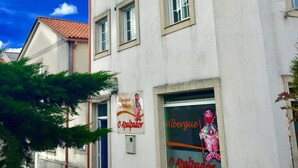 Un edificio con varias ventanas y un letrero que dice 'Albergue Turismo O Apalpador'.