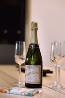 Una botella de vino Cava Brut y dos copas de vino vacías sobre una mesa.
