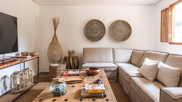 Een moderne woonkamer met een bank, salontafel en decoratieve accessoires.